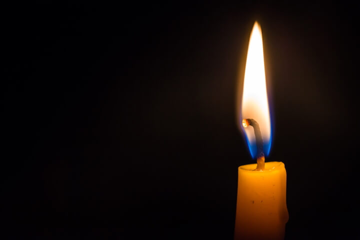 close-up light candle burning brightly black background