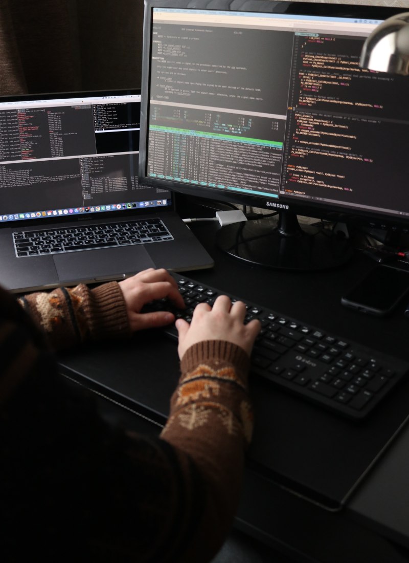 A software developer working on a PC showing code
